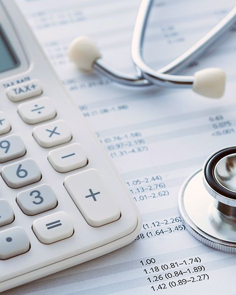 Calculator next to a stethoscope. 